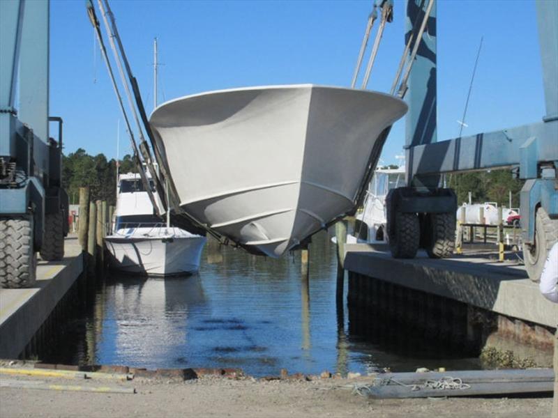 Hull 65 is flipped over the travel basin and touches water for the first time - 64' Custom Sportfish - photo © Jarrett Bay Boatworks