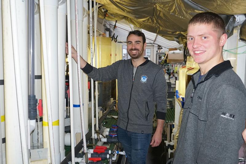 NOAA Postdoctoral Scholar Emilien Pousse (left) and Mass Maritime Academy student Jack Gerrior in front of the customized ocean acidification experimental system in the Massachusetts Maritime Academy's Aquaculture and Marine Sciences Laboratory. - photo © NOAA Fisheries